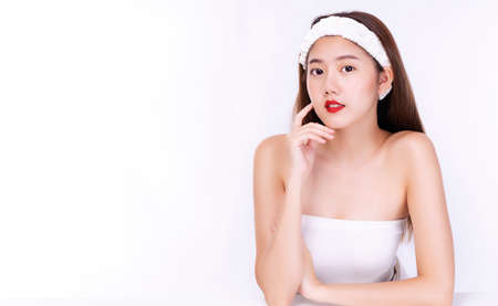 Beauty, cosmetics, healthy, treatment, skincare and spa concept. Asian young woman touching own face...