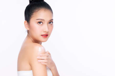 Portrait of smile young woman holding applying cosmetic cream or treatment moisturize in her body for skin care on isolated on white background. Healthy skin and cosmetics concept.の写真素材