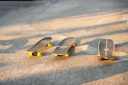 Hobby active athletic concept. Three surf skateboard balance on the street with sunlight leisure extreme sports at outdoor.の写真素材