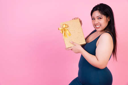 Celebration happy new year,  Christmas,anniversary, birthday concept. Smiling fat woman holding gold...