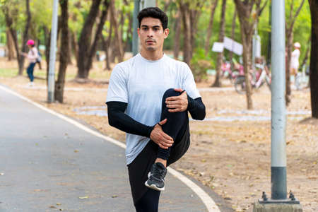 Lifestyle wellness healthy exercise activity concept. Happy sportsman stretching leg up warming body...