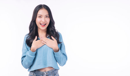 Excited asian woman casual holding hand shocked surprised sale product with copy space over white background. Cheerful young girl emotion amazed screaming wow something on isolated. Shopping  online.の写真素材