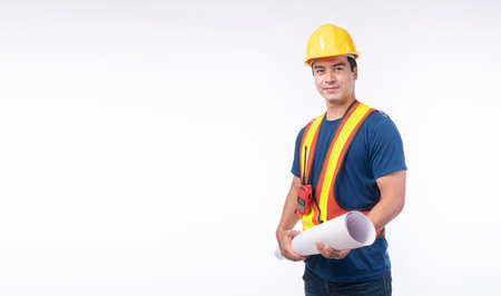 Thoughtful handsome man wear helmet safety holding blueprint standing on isolated white background. Engineer guy with walkie talkie holding plan blueprint building wear yellow hardhat white backgroundの写真素材