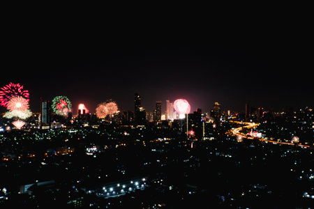 Blur landscape thailand countdown showing flowers fireworks bright nice viewing over buildings towers city in midnight new year. Beautiful shiny light fireworks festival modern city on dark sky night.の写真素材
