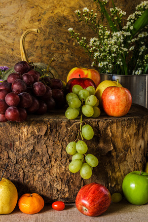 Still Life Fruits were placed on the timber with a beautiful vase of flowers.の写真素材