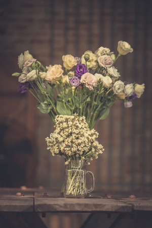 A bouquet of white flowers in a glass vase on a wooden floor boards of old vintage. The home decorの写真素材
