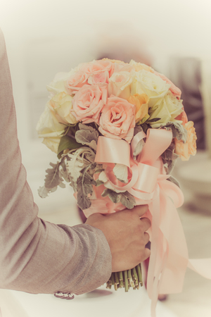 The groom was holding a bouquet of flowers to the wedding colors vintage.の写真素材