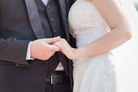 Bride and groom hand in hand With love and warmth at the wedding ceremony.の写真素材