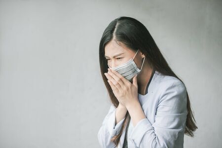 Women who have a cough and are sick with a flu infection,  covid-19, coronavirus, therefore have to use masks to cover the mouth and nose.の写真素材