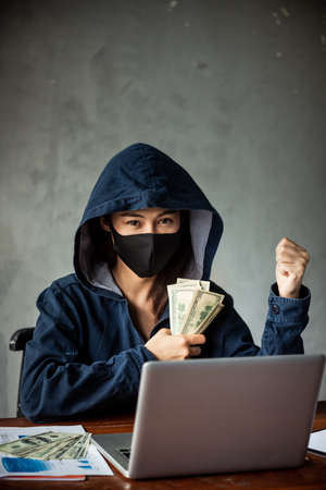 Professional hacker women Wearing a blue shirt with a hood Stealing data from online computer...