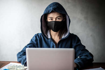 Professional hacker women Wearing a blue shirt with a hood Stealing data from online computer...