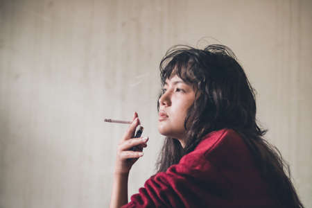 Stressed woman. A depressed woman smoking of stress Caused by social problems It's a concept about...