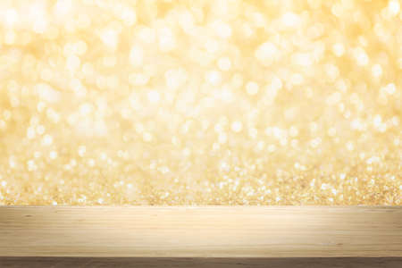 Gold color bright lights bokeh background of wooden table in front of lights abstract blurred and...