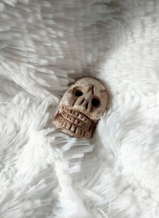 Skull sculpture on white synthetic hair textureの写真素材