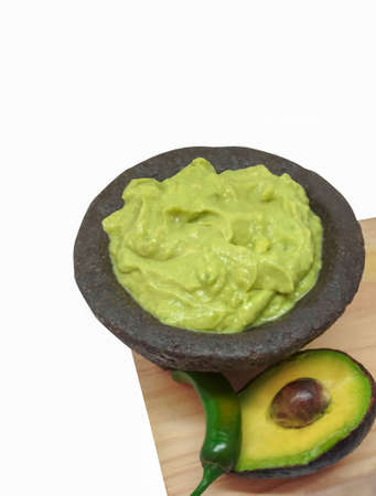 Guacamole in a molcajete, traditional Mexican of stone mortar. avocado and chili. White backgroundの写真素材