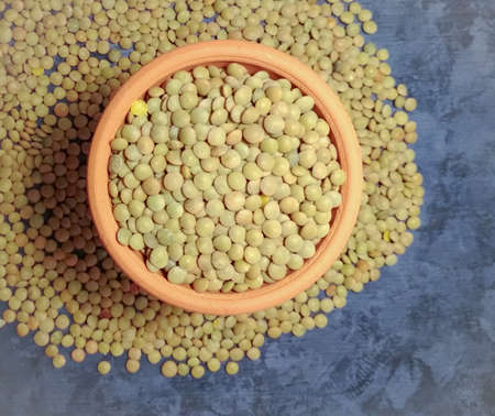 Lentils (Lens culinaris) in clay bowl on rustic gray wooden background. Top view with copy spaceの写真素材