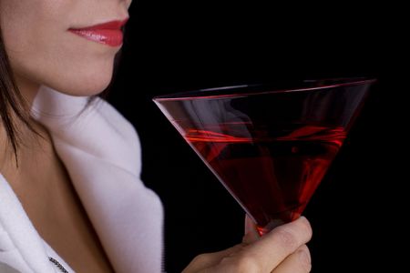 Woman with a red cocktail wearing a white coatの写真素材