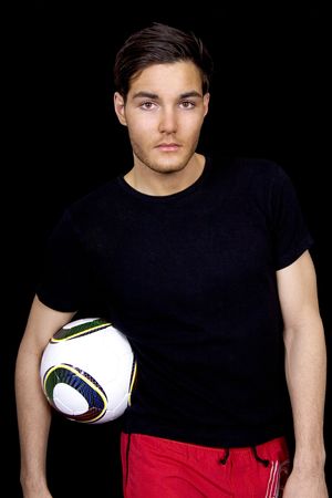 Handsome football player holding a ballの写真素材