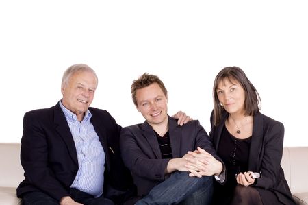 A senior couple and their adult son sitting in the sofa