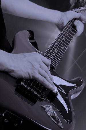 Man playing an electrical guitar at a rock concert