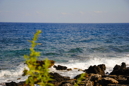 Rocky and sandy coast of Sisi on Crete in Greece with plants growing next to itの写真素材