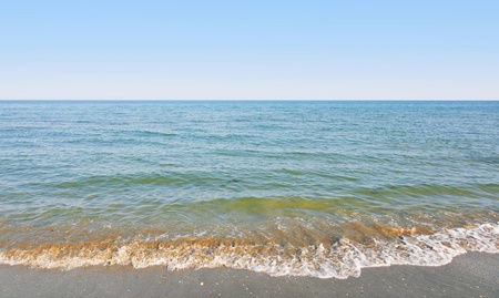 Peaceful island beach with gentle waves lapping the shoreの写真素材