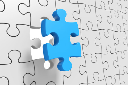 Puzzle solution, final jigsaw piece being inserted for completionの写真素材