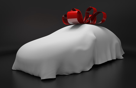 Auto concept of a new covered sports car topped with a red ribbon as a giftの写真素材
