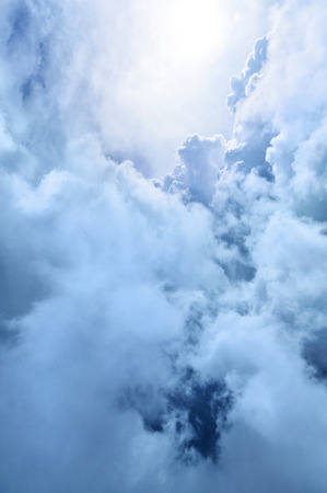 Heavenly blue and white clouds softly backlit by lightの写真素材