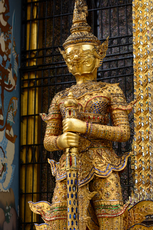 Gold yaksha demon at entrance to Phra Mondop library at historic Grand Palace in Bangkok, Thailandのeditorial素材
