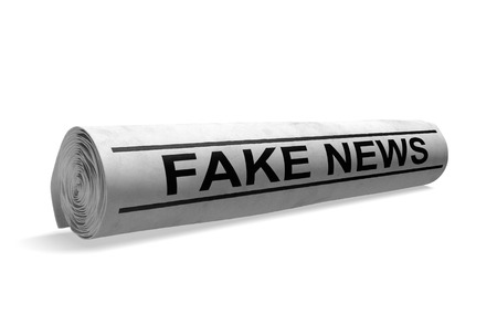 Rolled up newspaper with a fake news headline for bad media journalism, 3D renderingの写真素材