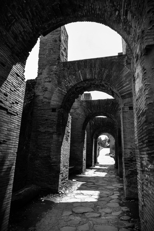 Black and white of ancient Roman arches repeating over a stone pathway in Rome, Italyの写真素材