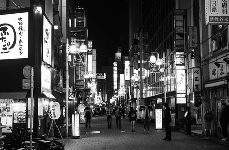TOKYO, JAPAN - APRIL 8, 2017 - Black and white of nightlife on a busy street in Tokyo full of illuminated advertisementsのeditorial素材