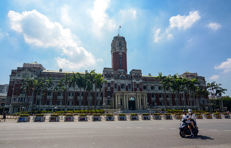 TAIPEI, TAIWAN - August 5, 2017 - A couple on a motorbike idles in front of the Presidential Office in Taipei, where the government conducts businessのeditorial素材