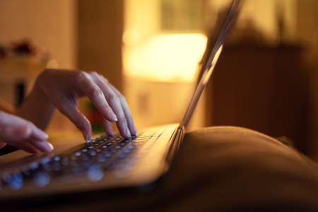 Shallow depth of field of lady typing on a laptop. Content is good for E-commerce or online shopping...