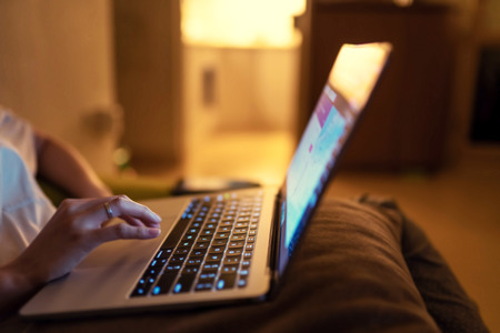 Shallow depth of field of lady doing research on laptop at her comfortable home. Content is good for...