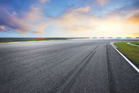 Dramatic view of racing asphalt road with evening sky.