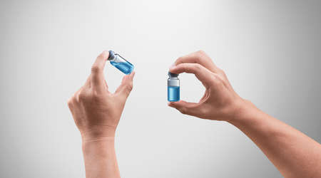 Doctor hands inspecting medical drug. Bright grey background. Medical concept for health care,...