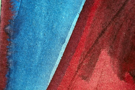 Red and blue stains on brown paper.の写真素材
