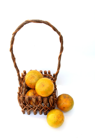 oranges are  in the basket and two on the groundの写真素材