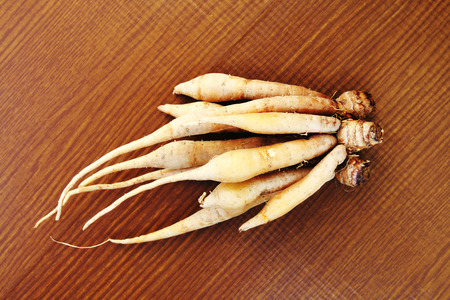 bunch of long fingerroot on wooden backgroundの写真素材