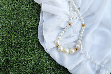 plastic perl necklace is on the white fabricの写真素材