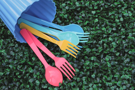 plastic spoons and forks are pouring on the artificial turfの写真素材