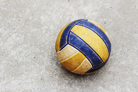 old volleyball rolling on the concrete floor in soft focusの写真素材