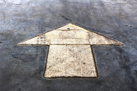old arrow sign on the floor in the parking lotの写真素材