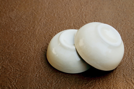 two ceramic bowls are on the bround paper backgroundの写真素材