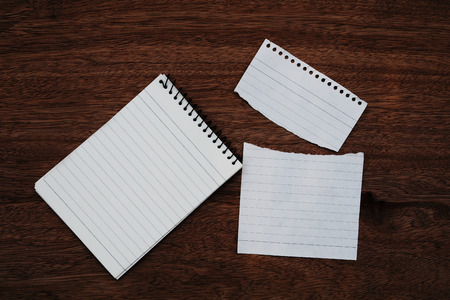 notepad and torn paper on dark wooden backgroundの写真素材