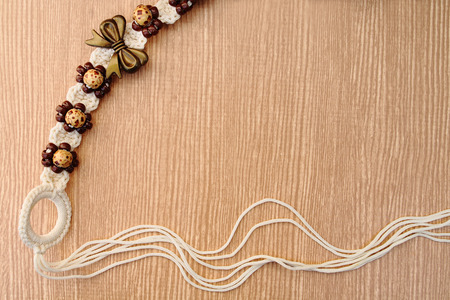 belt made from wool woven  and wooden bead on wooden background