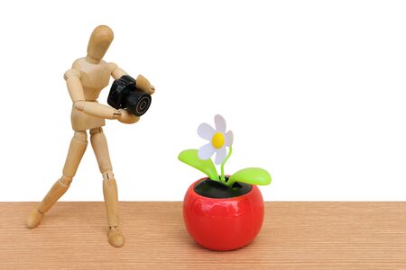puppet doll take a picture from flower pot ,isolate white backgroundの写真素材