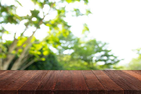 Wood floor with blurred trees of nature park background and summer season, product display montage
